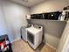 Clean laundry room with modern washer and dryer and storage shelves at 10383 Andele Ave, Las Vegas, NV 89166