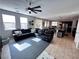Open-concept living room featuring a leather sectional, ceiling fan, and seamless transition to the kitchen at 10383 Andele Ave, Las Vegas, NV 89166