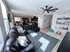 Inviting living room with dark leather sectional, ceiling fan, and an open view into the kitchen area at 10383 Andele Ave, Las Vegas, NV 89166