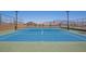 A blue and green tennis court is surrounded by fencing with mountain views at 10383 Andele Ave, Las Vegas, NV 89166