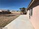 Spacious backyard featuring desert landscaping, a concrete patio, and mature palm trees at 1083 Sterling Peak St, Las Vegas, NV 89110