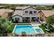 Aerial view of a backyard oasis with a sparkling pool, spa, patio, and lush landscaping at 11 Morninglow Pass, Henderson, NV 89052