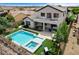 Inviting backyard with a pristine pool and spa, upper balcony, outdoor seating and dining, and desert landscape at 11 Morninglow Pass, Henderson, NV 89052