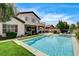 Spacious backyard features a pool, patio, second-story balcony, and a built-in outdoor kitchen at 11 Morninglow Pass, Henderson, NV 89052