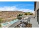 Balcony with seating overlooking the pool and backyard with hillside views at 11 Morninglow Pass, Henderson, NV 89052