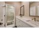 Bathroom features a double sink vanity, white cabinets, and a tiled shower with glass door at 11 Morninglow Pass, Henderson, NV 89052