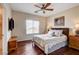 Bedroom features hardwood floors, a ceiling fan, and a comfortable bed with decorative pillows at 11 Morninglow Pass, Henderson, NV 89052