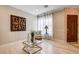 Bright foyer features white sheer curtains, light wood floors and decorative wall art at 11 Morninglow Pass, Henderson, NV 89052