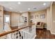 Hallway features hardwood floors, white banister staircase, and views to rooms throughout the home at 11 Morninglow Pass, Henderson, NV 89052