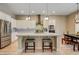 Open concept kitchen featuring a spacious island with seating, stainless steel appliances, and adjacent dining area at 11 Morninglow Pass, Henderson, NV 89052