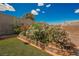 A landscaped backyard with vibrant flowers, brick planters, and an artificial grass lawn at 111 Pomelo Ct, Henderson, NV 89074