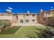 A backyard with artificial grass, concrete patio and mature landscaping providing a private outdoor area at 111 Pomelo Ct, Henderson, NV 89074