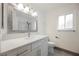Bright bathroom with large mirror, white cabinets, and quartz countertop at 111 Pomelo Ct, Henderson, NV 89074