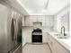 Modern kitchen with stainless steel appliances, white cabinets, and designer backsplash at 111 Pomelo Ct, Henderson, NV 89074