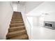 Inviting living room featuring a brick fireplace, a ceiling fan, and staircase access at 111 Pomelo Ct, Henderson, NV 89074