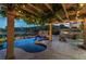 The backyard has a custom pool, rock waterfall, built-in BBQ, and a cozy fire pit for year-round enjoyment at 11359 Winter Cottage Pl, Las Vegas, NV 89135