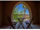 View through arch of outdoor balcony furnished with table and chairs at 11359 Winter Cottage Pl, Las Vegas, NV 89135