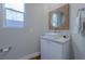 Modern half bathroom featuring a stylish vanity with a vessel sink and decorative mirror at 11359 Winter Cottage Pl, Las Vegas, NV 89135