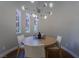 Bright dining area with a round table, modern light fixture, and natural light streaming through the windows at 11359 Winter Cottage Pl, Las Vegas, NV 89135