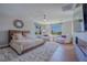 Spacious main bedroom with hardwood floors, a cozy bed, sitting area, and a modern fireplace at 11359 Winter Cottage Pl, Las Vegas, NV 89135