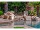 Gorgeous backyard pool with rock features and lush tropical landscaping creates a tranquil retreat at 11359 Winter Cottage Pl, Las Vegas, NV 89135