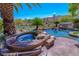 Beautiful backyard pool and spa with rock features and lush landscaping offer a relaxing oasis at 11359 Winter Cottage Pl, Las Vegas, NV 89135