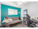 Bedroom featuring teal accent wall, natural light, and a modern black desk chair at 11739 Village Arbor St, Las Vegas, NV 89183