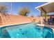 Relaxing backyard pool features a covered patio and is surrounded by a brick wall, perfect for outdoor enjoyment at 11739 Village Arbor St, Las Vegas, NV 89183