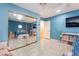 Bright bedroom featuring tile floors, a large mirrored closet, and a TV at 120 N Phyllis St, Las Vegas, NV 89110
