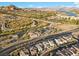Stunning aerial view of a desert community featuring a golf course, lake, and mountains in the distance at 14 Parco Fiore Ct, Henderson, NV 89011