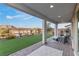Inviting covered patio with ample seating, brick flooring, and a view of the manicured backyard at 14 Parco Fiore Ct, Henderson, NV 89011