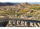 An aerial view of a neighborhood featuring desert landscaping, mountain views, and nearby shopping at 14 Parco Fiore Ct, Henderson, NV 89011