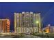 A vibrant night view of a high-rise building complex in a bustling urban setting with a distinctive architectural design at 150 Las Vegas Blvd # 1912, Las Vegas, NV 89101