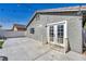 Backyard view features a back patio, gray siding, a gated area, and outdoor access door at 1714 Ringe Ln, Las Vegas, NV 89156
