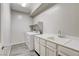 Well-lit laundry room with modern appliances, sink, white cabinets, and tiled floor at 172 Petaluma Valley Dr, Las Vegas, NV 89138