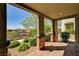 Charming covered patio featuring brick pillars, lush landscaping, and a serene view at 172 Petaluma Valley Dr, Las Vegas, NV 89138