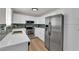 Bright kitchen features stainless steel appliances, white cabinets, quartz countertops, and stylish backsplash at 2112 Santa Ynez Dr, Las Vegas, NV 89104
