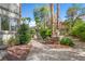 Lush backyard space with charming walkway, mature trees, a decorative fountain, and desert landscaping at 253 White Willow Ave, Las Vegas, NV 89123