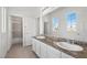 Bathroom featuring dual sinks, granite countertops, neutral walls, and a glass shower at 253 White Willow Ave, Las Vegas, NV 89123