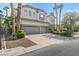 Two-story home featuring a three-car garage, stucco and brick exterior, and professionally landscaped front yard at 253 White Willow Ave, Las Vegas, NV 89123