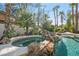 A pool and hot tub surrounded by rocks and landscaping at 253 White Willow Ave, Las Vegas, NV 89123