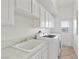 Laundry room features all white cabinets, tile floors and a sink at 253 White Willow Ave, Las Vegas, NV 89123