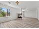 Spacious living room with fireplace, wood-look floors, and sunlit windows at 253 White Willow Ave, Las Vegas, NV 89123