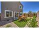 The backyard offers a serene dining area with outdoor table set, gravel, and green turf at 2633 Begonia Falls Ave # 88, North Las Vegas, NV 89081
