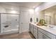 Bright bathroom featuring double sinks, white cabinetry, and a glass-enclosed shower for a spa-like feel at 2633 Begonia Falls Ave # 88, North Las Vegas, NV 89081