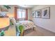 A cheerful bedroom with dinosaur themed decor, carpeted flooring, and a bright window at 2633 Begonia Falls Ave # 88, North Las Vegas, NV 89081