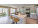 Bright kitchen features stainless appliances, quartz countertops, an island with seating, and backyard view at 2633 Begonia Falls Ave # 88, North Las Vegas, NV 89081