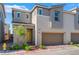 Charming townhome with a two-car garage, yellow front door and low-maintenance landscaping at 2691 Mango Light Ave, North Las Vegas, NV 89086
