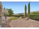 Lush backyard featuring desert landscaping, trimmed hedges and an intimate patio area at 2810 Somerset Springs Dr, Henderson, NV 89052