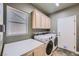 A functional laundry room with washer, dryer, cabinets, and a window providing natural light at 2810 Somerset Springs Dr, Henderson, NV 89052